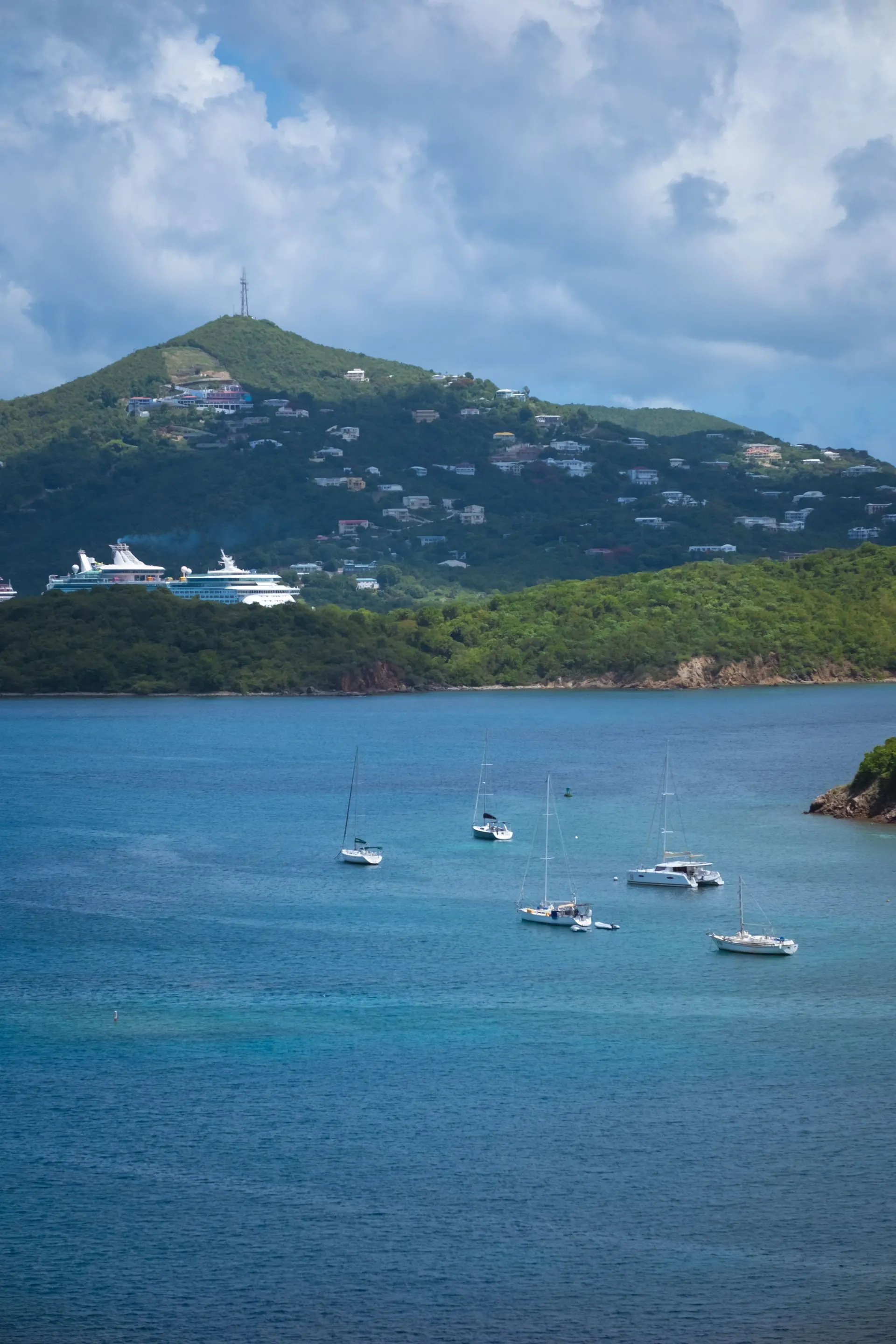 Baia caraibica con barche a vela e una nave da crociera