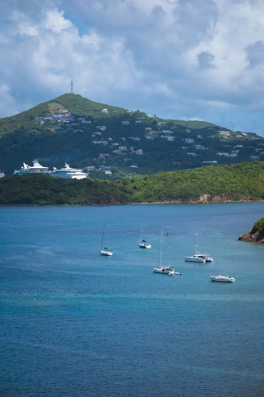 Baia caraibica con barche a vela e una nave da crociera